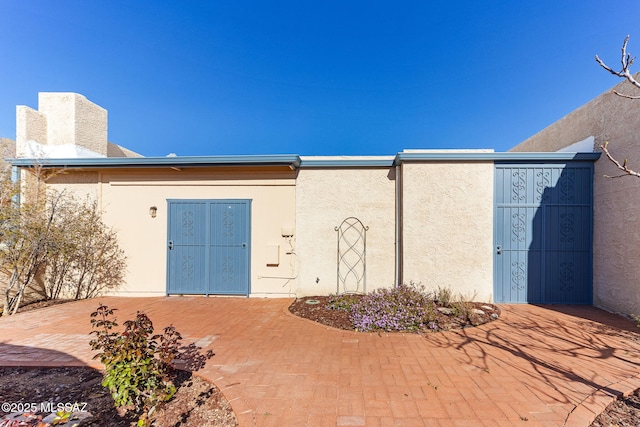 exterior space featuring stucco siding and a patio