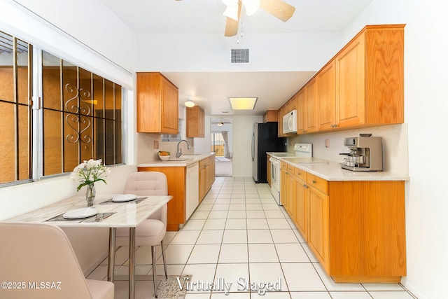 kitchen featuring visible vents, white appliances, ceiling fan, and light countertops