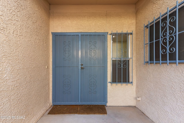 view of exterior entry with stucco siding