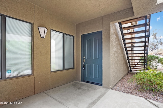 entrance to property featuring stucco siding