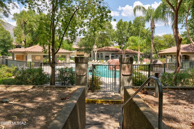 exterior space with a community pool and fence