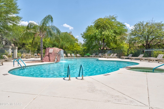 pool with a community hot tub, a patio area, and fence