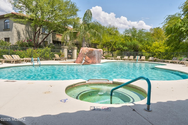 pool featuring a patio area, fence, and a hot tub