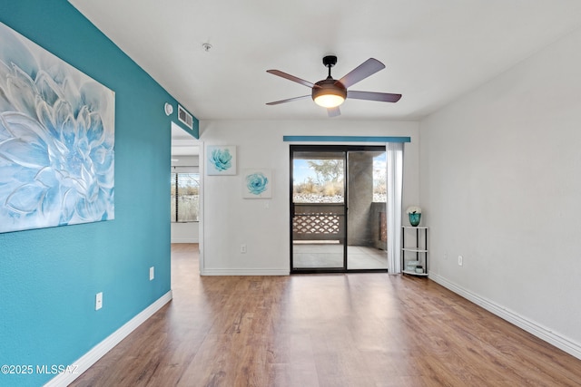 unfurnished room with wood finished floors, baseboards, and ceiling fan