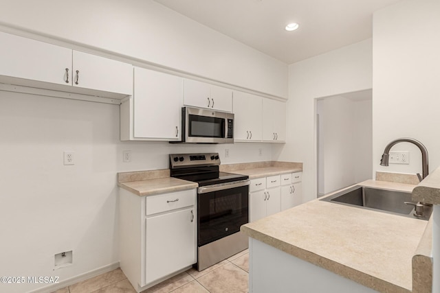 kitchen featuring light tile patterned flooring, stainless steel appliances, recessed lighting, white cabinetry, and a sink