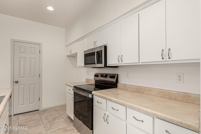 kitchen with light countertops, stainless steel appliances, recessed lighting, white cabinetry, and light tile patterned floors