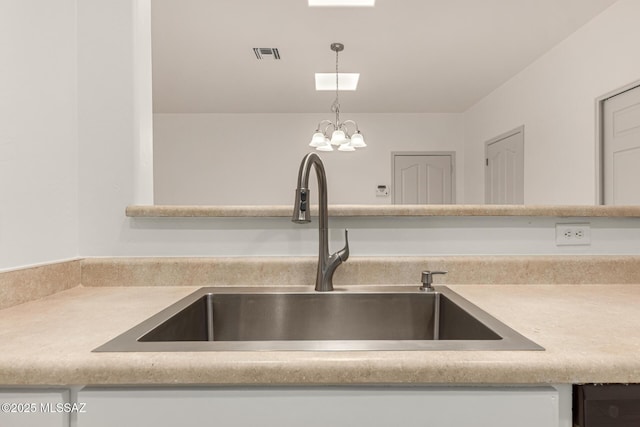details with visible vents, light countertops, a sink, and decorative light fixtures