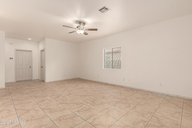 empty room with baseboards, visible vents, and ceiling fan