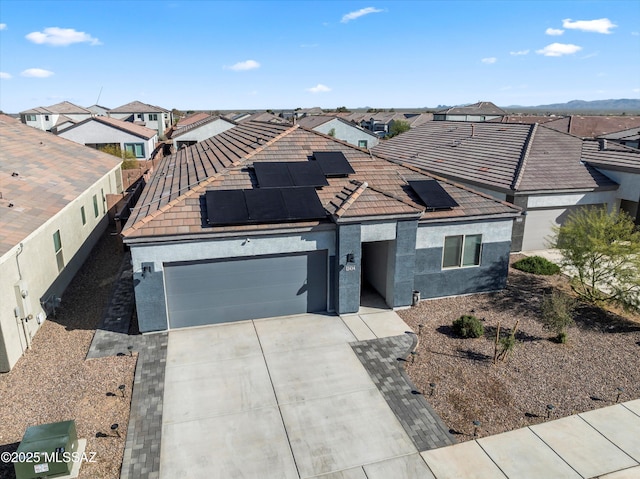 view of front of house featuring a residential view, stucco siding, driveway, and a garage