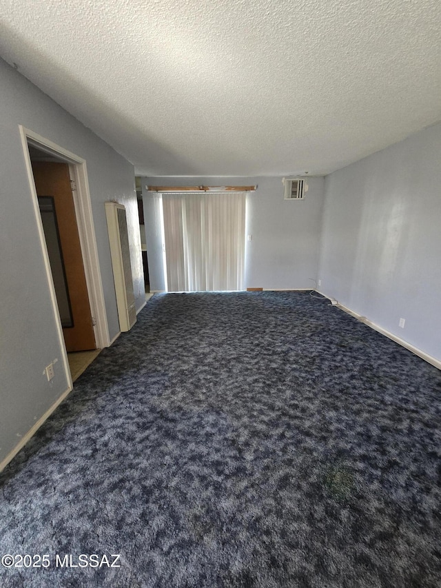 empty room with baseboards, carpet, visible vents, and a textured ceiling