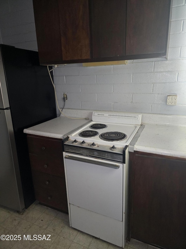 kitchen featuring light countertops, white electric stove, and dark brown cabinets