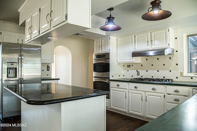 kitchen featuring appliances with stainless steel finishes, white cabinetry, under cabinet range hood, and decorative backsplash