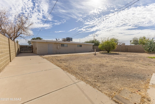 back of property featuring fence private yard, central AC unit, and stucco siding