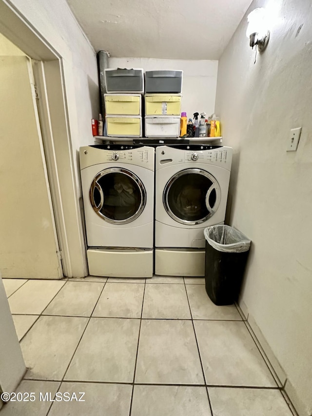 washroom with washer and dryer, laundry area, and light tile patterned floors