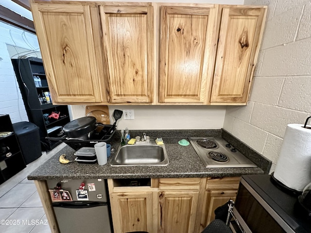 kitchen featuring light brown cabinets, light tile patterned floors, a sink, and stainless steel electric cooktop