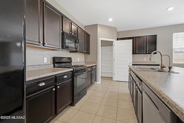 kitchen featuring recessed lighting, light countertops, light tile patterned flooring, a sink, and black appliances