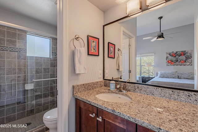 ensuite bathroom with toilet, connected bathroom, a shower stall, ceiling fan, and vanity