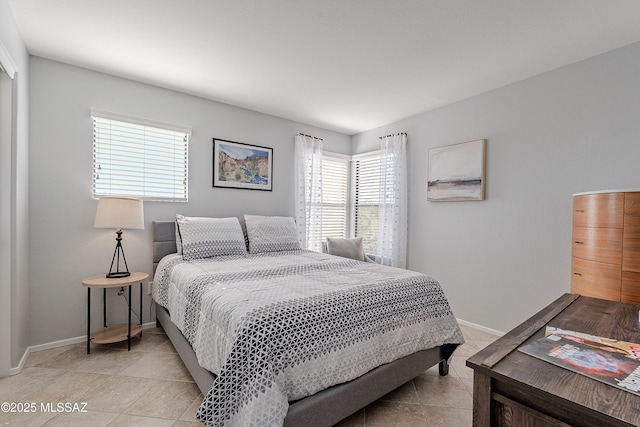 bedroom with baseboards and light tile patterned flooring