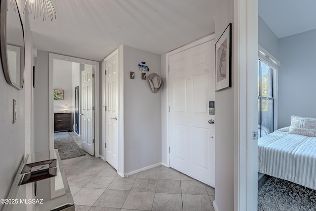 foyer with light tile patterned flooring and baseboards