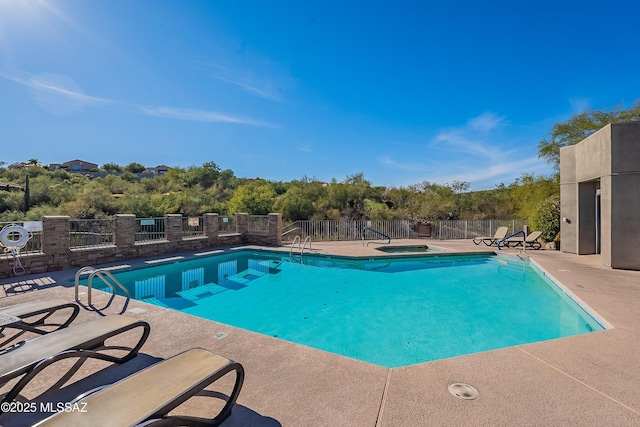 community pool featuring a patio area and fence