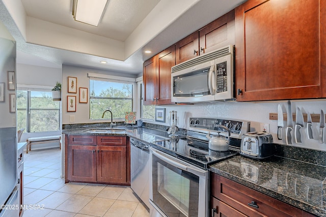 kitchen featuring a sink, light tile patterned flooring, a wealth of natural light, and stainless steel appliances