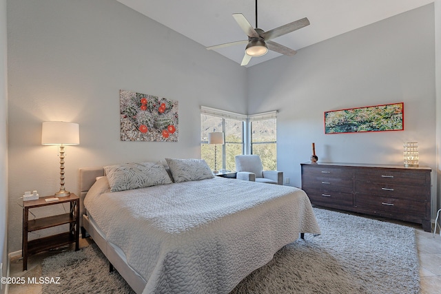 bedroom featuring baseboards, high vaulted ceiling, and a ceiling fan