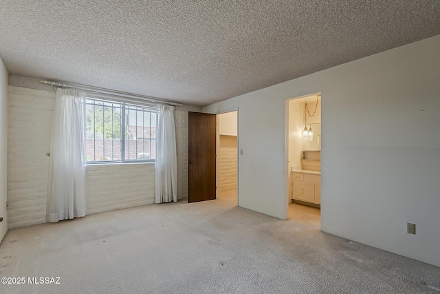 unfurnished bedroom with light carpet, a textured ceiling, and connected bathroom