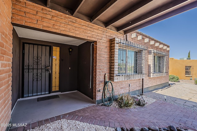 doorway to property with brick siding
