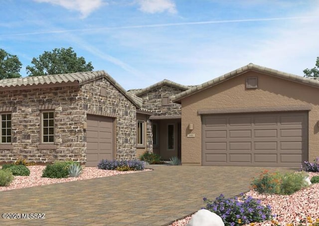 view of front of property featuring decorative driveway, a tile roof, an attached garage, and stucco siding