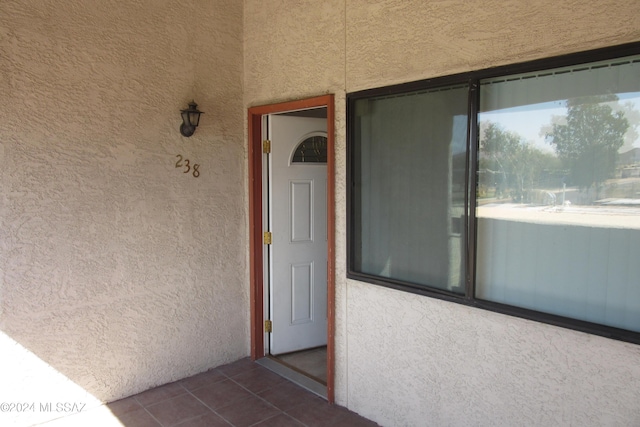 doorway to property featuring stucco siding