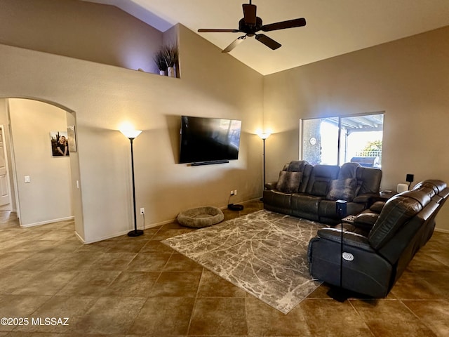 tiled living room featuring high vaulted ceiling, baseboards, arched walkways, and a ceiling fan