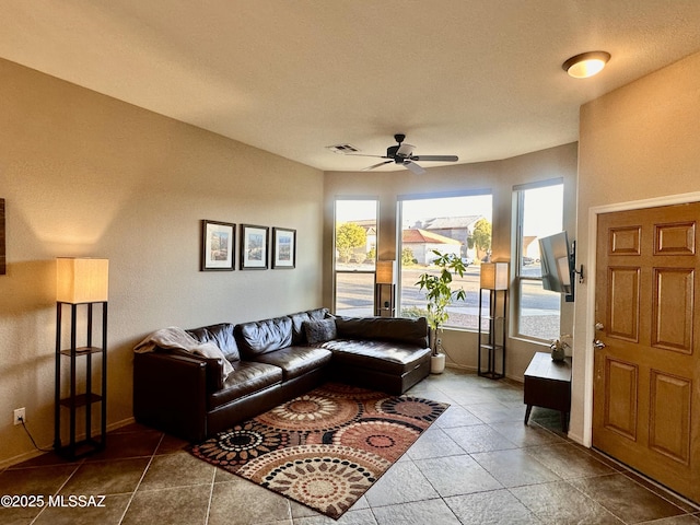 living area featuring baseboards, visible vents, and a ceiling fan