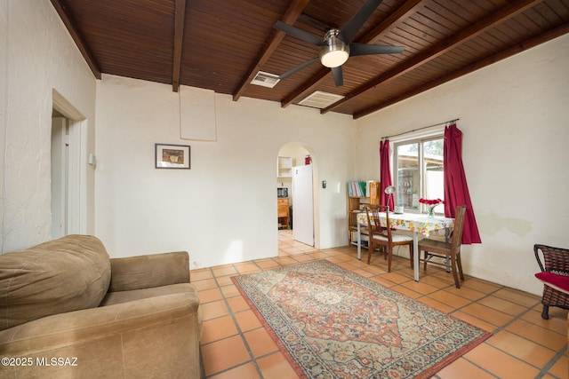 living room with arched walkways, beamed ceiling, tile patterned flooring, and wood ceiling