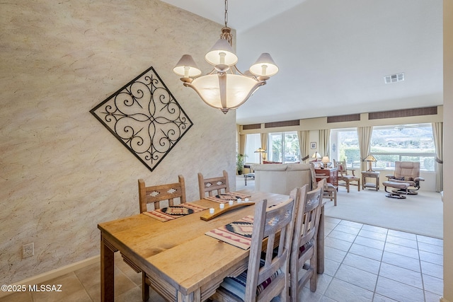 dining room featuring light tile patterned floors, visible vents, light colored carpet, and a chandelier