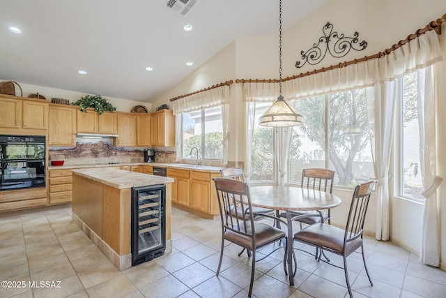 kitchen with visible vents, black appliances, beverage cooler, light brown cabinetry, and light countertops