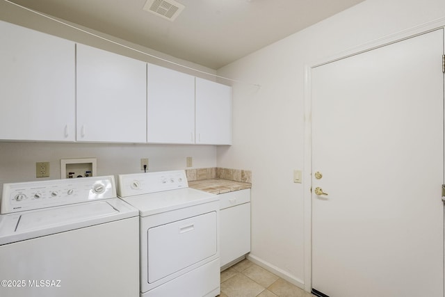 clothes washing area featuring light tile patterned flooring, visible vents, cabinet space, and independent washer and dryer