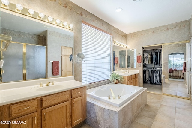 bathroom with two vanities, a sink, a shower stall, tile patterned floors, and a bath