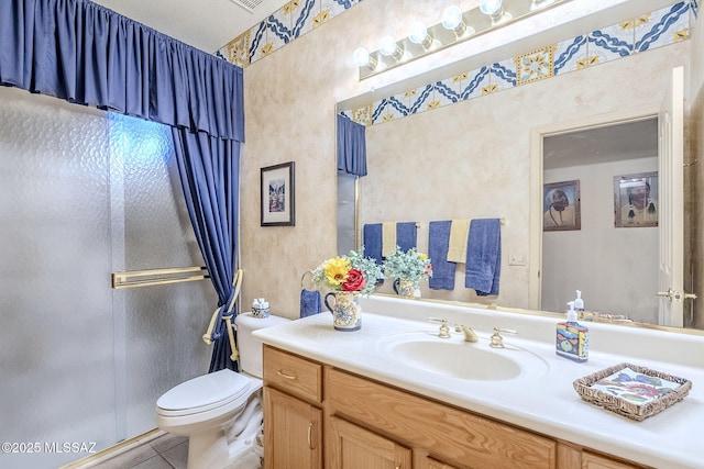 bathroom featuring tile patterned flooring, a shower stall, toilet, and vanity