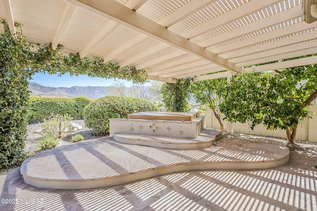 view of patio featuring a pergola, a covered hot tub, fence, and a mountain view