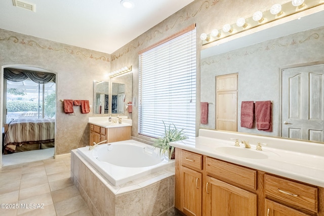 bathroom featuring visible vents, wallpapered walls, a sink, a garden tub, and connected bathroom