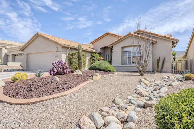 single story home featuring a garage, a tile roof, concrete driveway, and stucco siding