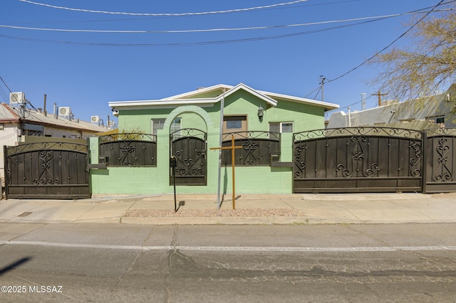 view of front of property featuring a fenced front yard, a gate, and stucco siding