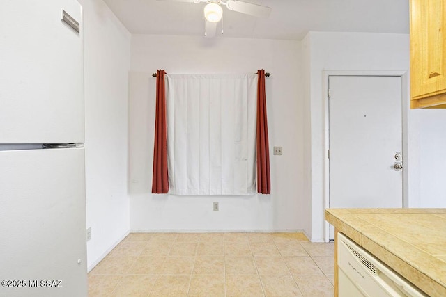 interior space with ceiling fan, white appliances, and light tile patterned flooring