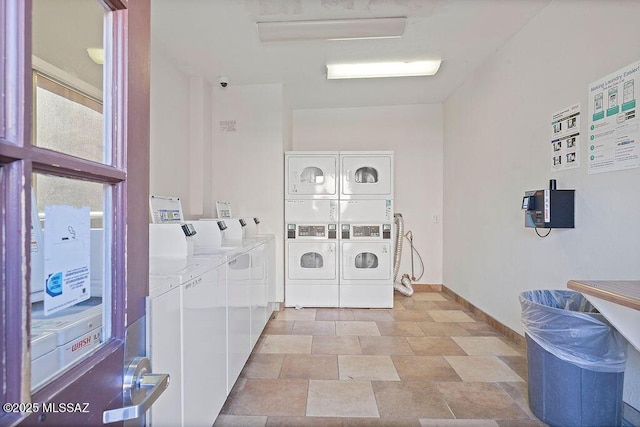 common laundry area featuring baseboards, stacked washing maching and dryer, and separate washer and dryer