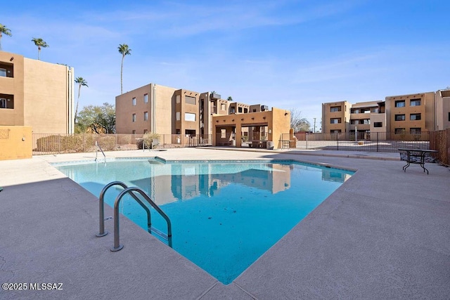 community pool featuring fence and a patio