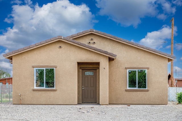 view of front of house featuring fence and stucco siding