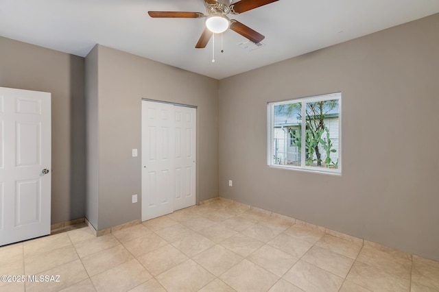 unfurnished bedroom with a ceiling fan, a closet, visible vents, and light tile patterned flooring