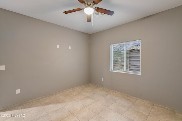 empty room featuring ceiling fan, visible vents, and light tile patterned flooring