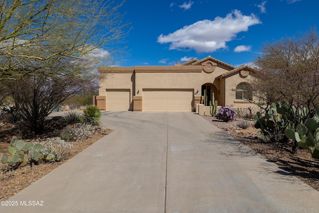 view of front of house featuring a garage, driveway, and stucco siding