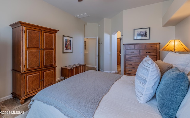 bedroom featuring arched walkways, visible vents, and baseboards